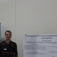 Student standing next to an electrical engineering presentation.